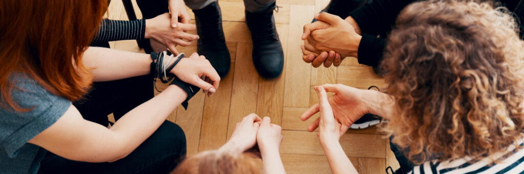 Overhead shot of family holding hands in a circle, facing each other