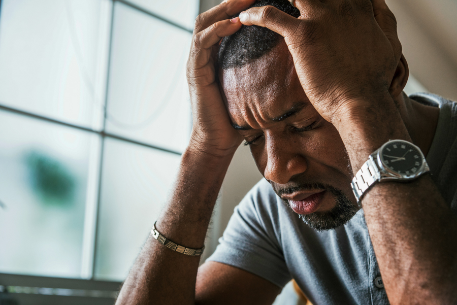 Close shot of a man holding his head in frustration