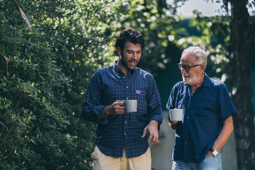 Two men in an intensive outpatient program taking while drinking coffee outside