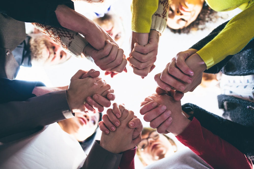 Members of codependent relationship holding hands and looking down