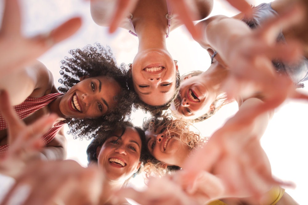 Overhead shot of four women having fun and looking down at the camera