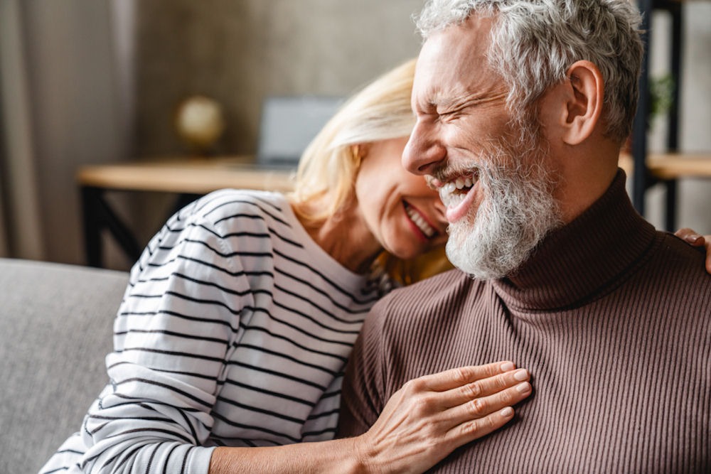 Woman curling into smiling male partner dealing with depression