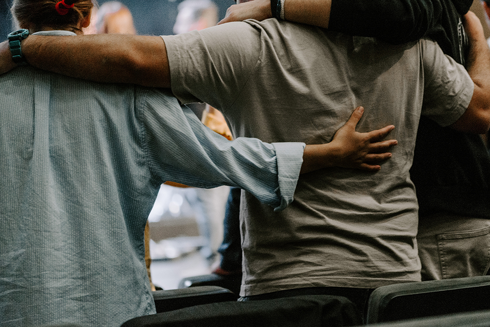 Rear view of group of men embracing each others' sides