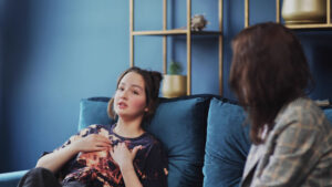 Young woman laying down on a couch describing seasonal depression to therapist