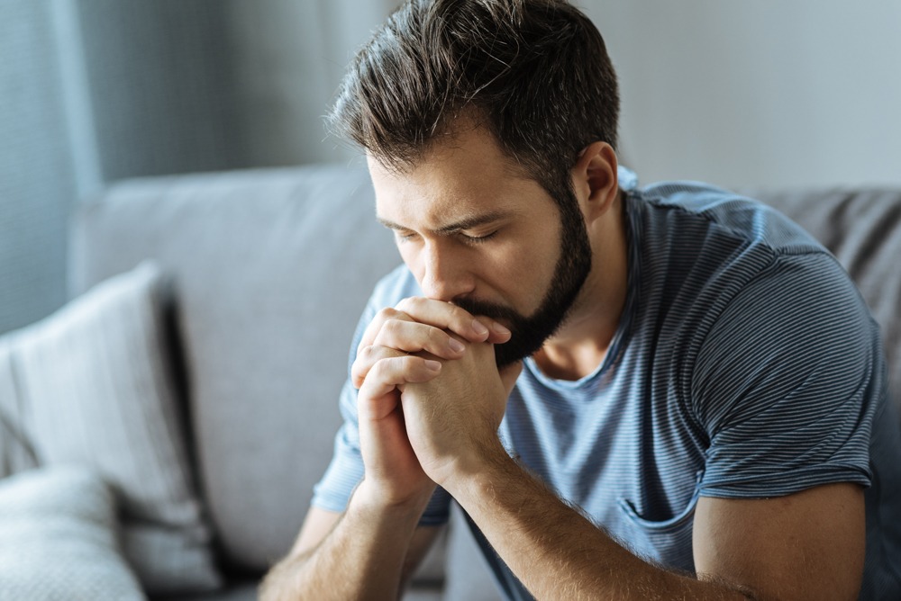 Man with depression in early recovery thinking with hands close to face