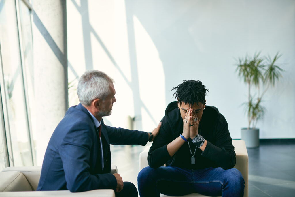 Therapist consoles young man learning about iso fentanyl