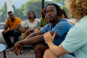 Woman comforting man opemomg up about resilience in addiction recovery group