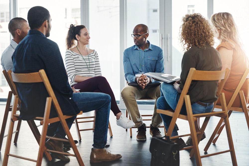 Circle of people in addiction recovery group talking about resilience