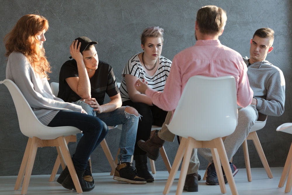 Group therapy at a sober living home having a heavy discussion