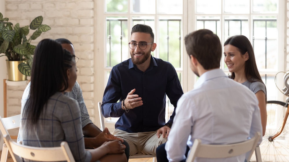 Man with glasses conducting opioid addiction support group