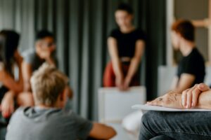 Therapist monitors addiction support group where people are sharing.