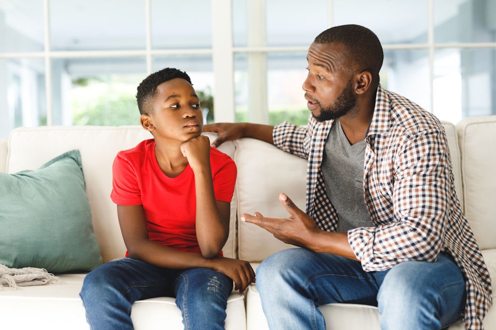 Man discusses addiction with young son.
