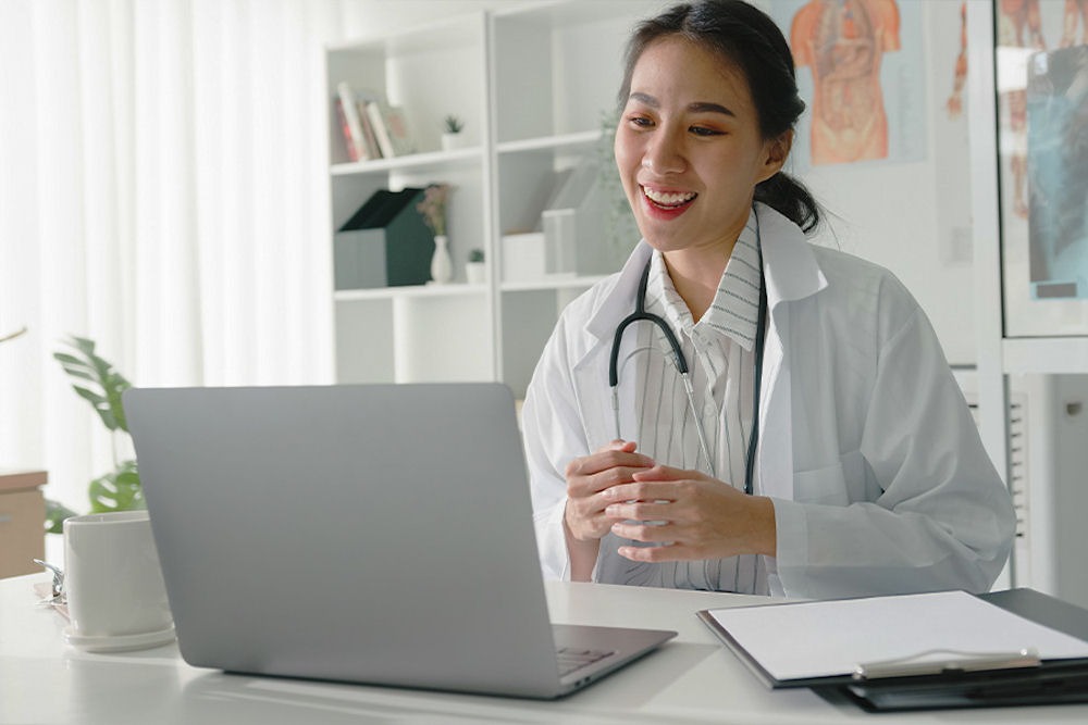 Doctor smiling while conducting telehealth session.