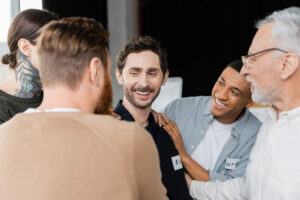 Man with eating disorder being braced by other men in support group.