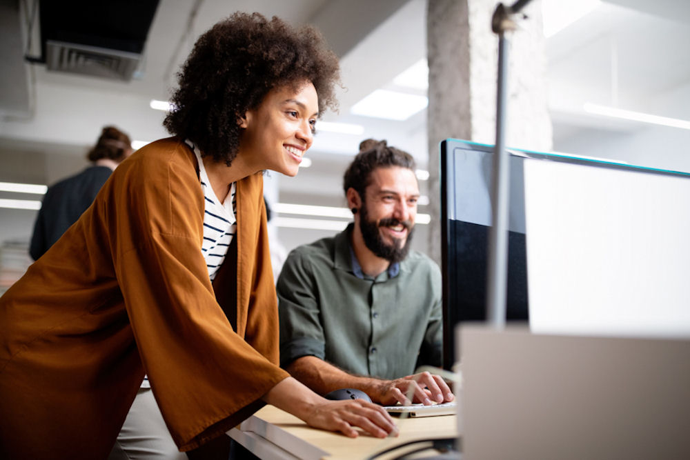 The Best Jobs for People with Depression 1 Woman in sweater leaning over desk to assist man with bun.