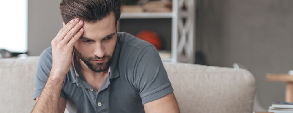 Man holding his head while having a silent panic attack.