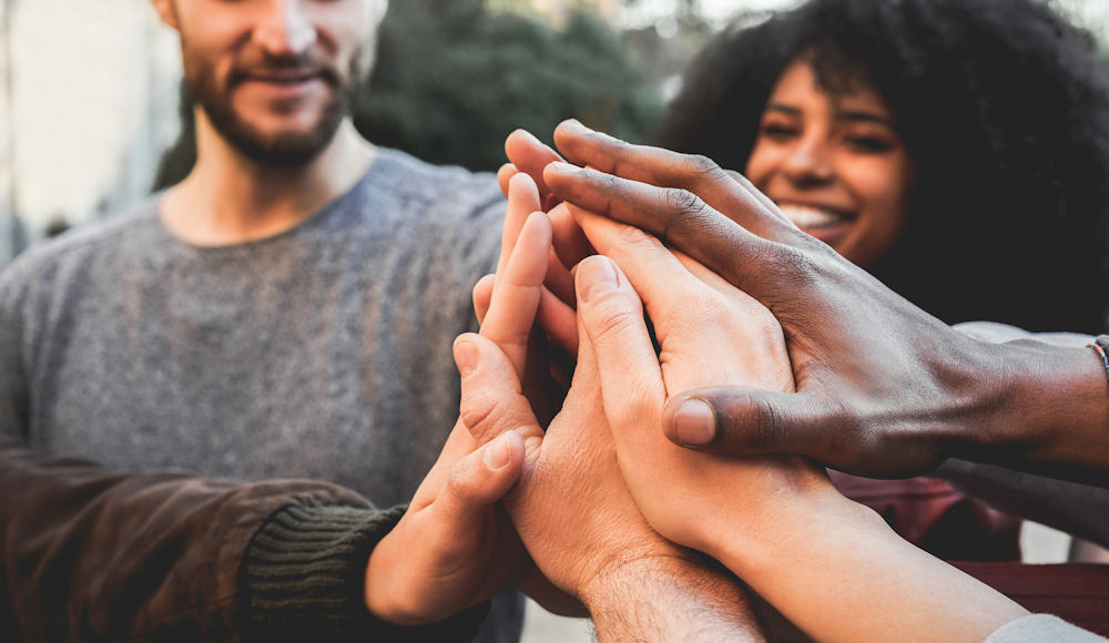 Group of people facing relationship addiction bracing each other's hands.