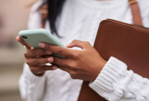Woman reading news about political anxiety from a mint green smartphone.