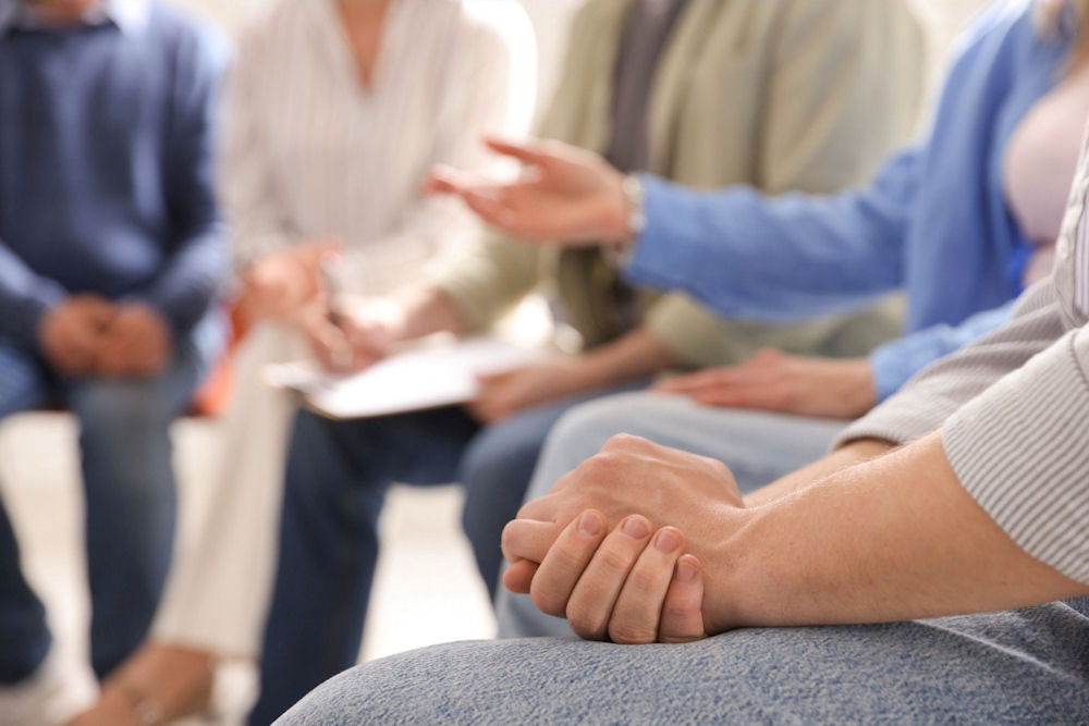 Group of people in an AA meeting talking about Step Three