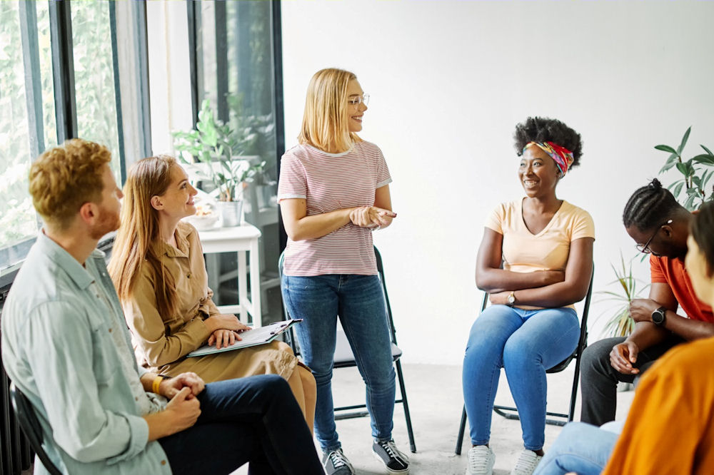 Woman standing up while talking about step three in an AA meeting