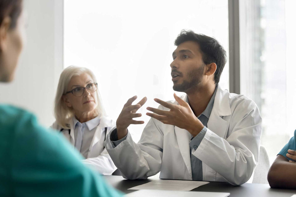 Young doctor speaking at meeting of doctors on when a functional alcoholic shoulf send help.