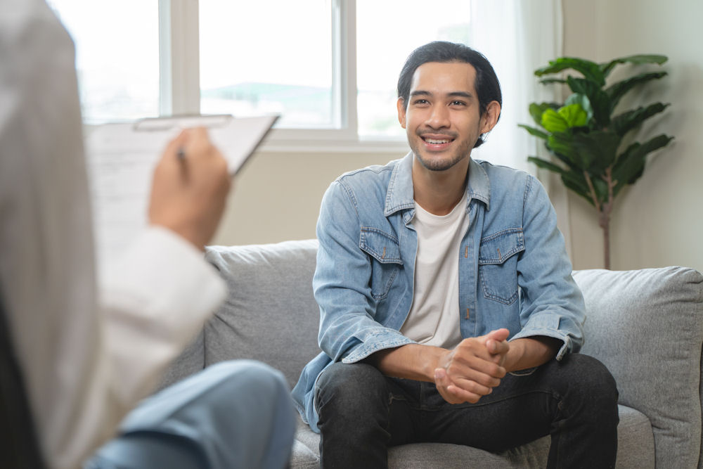 Man smiling at therapist while undergoing therapy for ecstasy