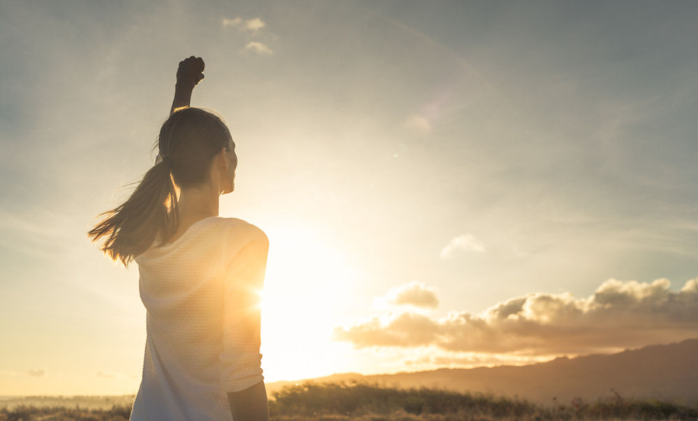 Woman holding up fist in triumph after completing a run for anxiety relief.