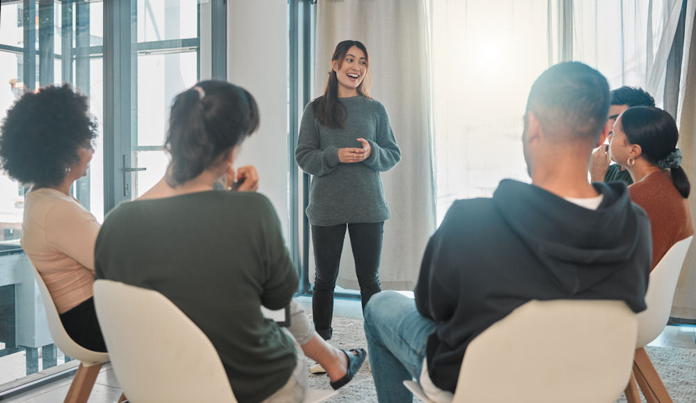 Woman speaking up about captagon in group therapy for addiction.