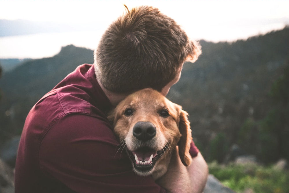 man embracing dog for relief from anxiety disorder.