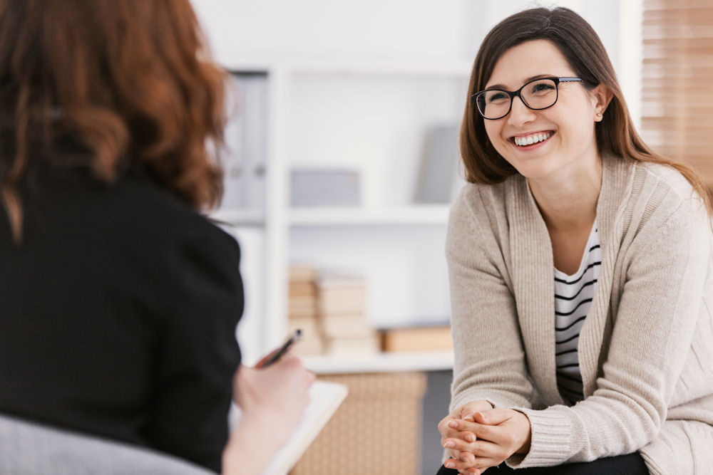 Addiction Treatment in Clovis, CA 2 Woman listening to therapist in office in Clovis, California.