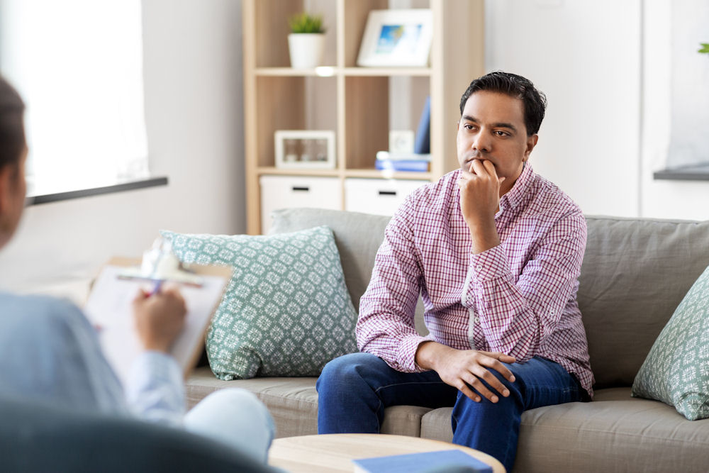 man thinking about virtual IOP vs in-person IOP